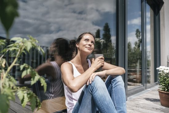 Smiling woman relaxing on balcony