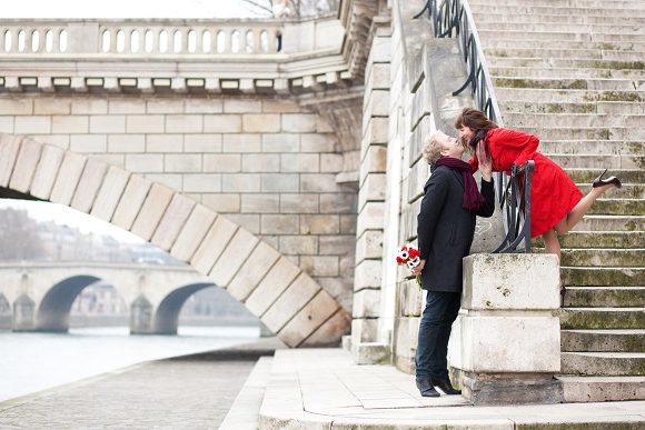 Romantic couple kissing on a Parisian embankment