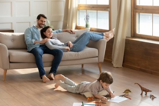 Happy,Young,Caucasian,Parents,Relax,On,Cozy,Couch,In,Living