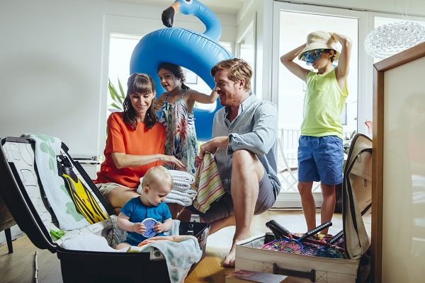 Happy family of five packing for holiday trip